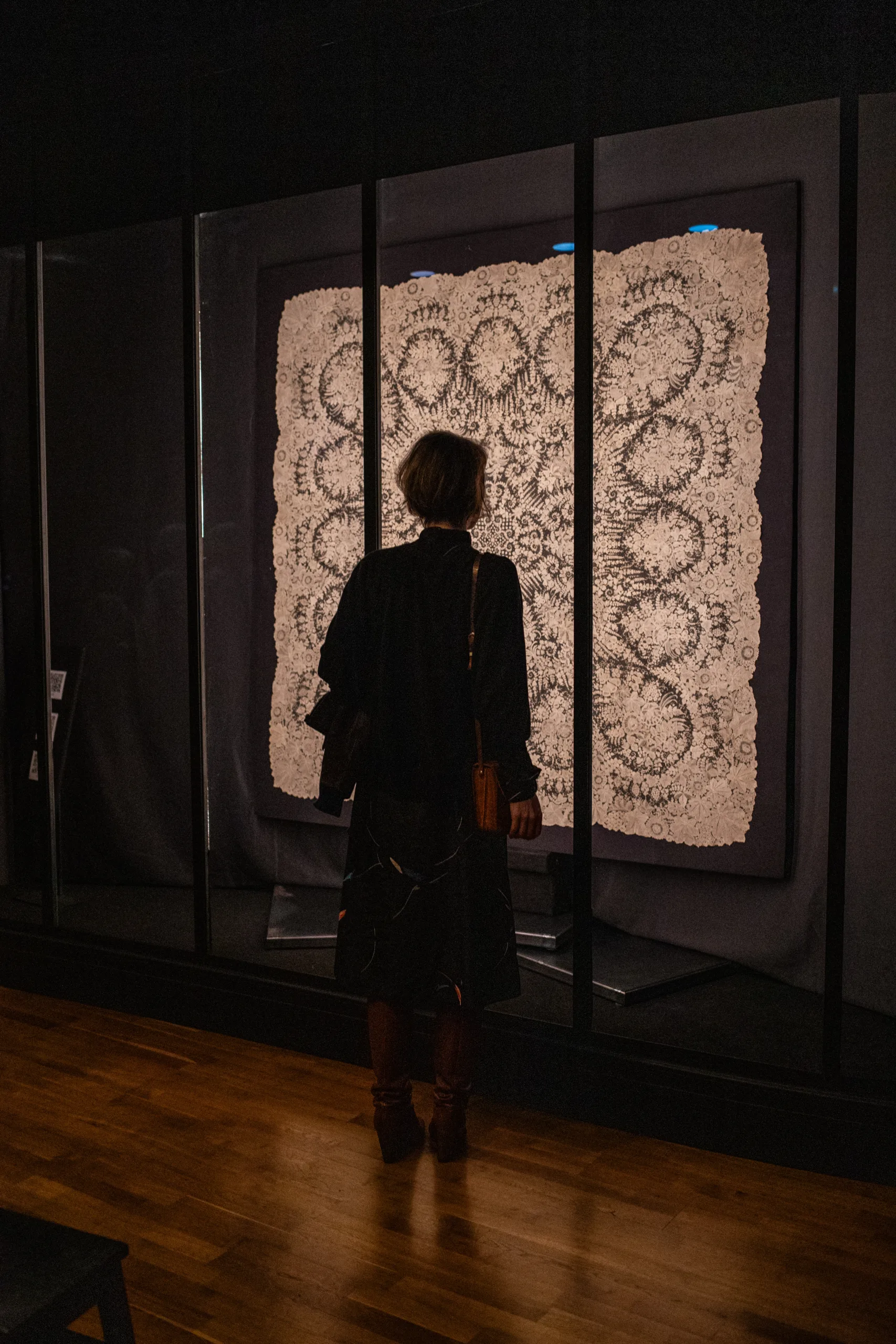 Large white lace measuring roughly 2 by 2 meters, with a visitor admiring it